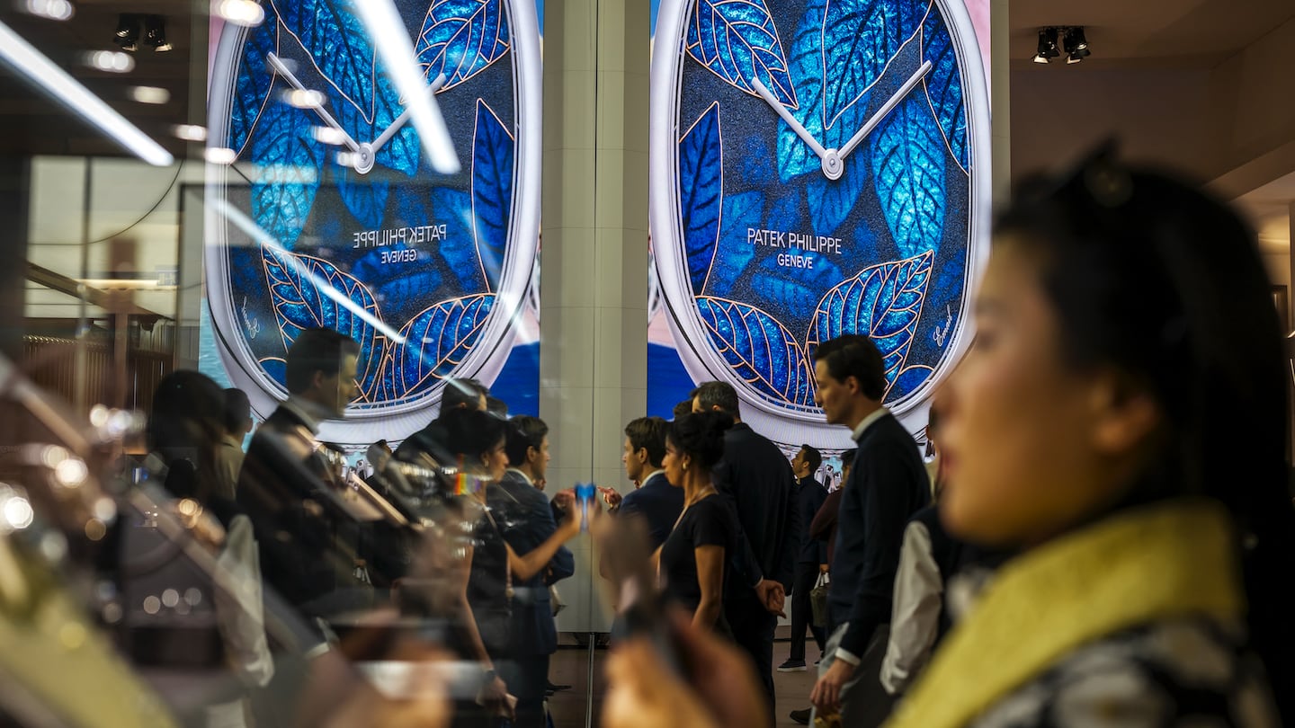 Visitors look at watches on display at the booth of Swiss luxury watch and clock manufacturer Patek Philippe, during the opening day of the "Watches and Wonders Geneva" luxury watch fair, in Geneva on April 1, 2025.