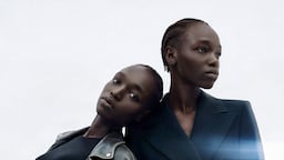 Two versions of model Nyajuok Gatdet pose for a photograph, one in a double breasted blazer and the other in a leather jacket and bodysuit.