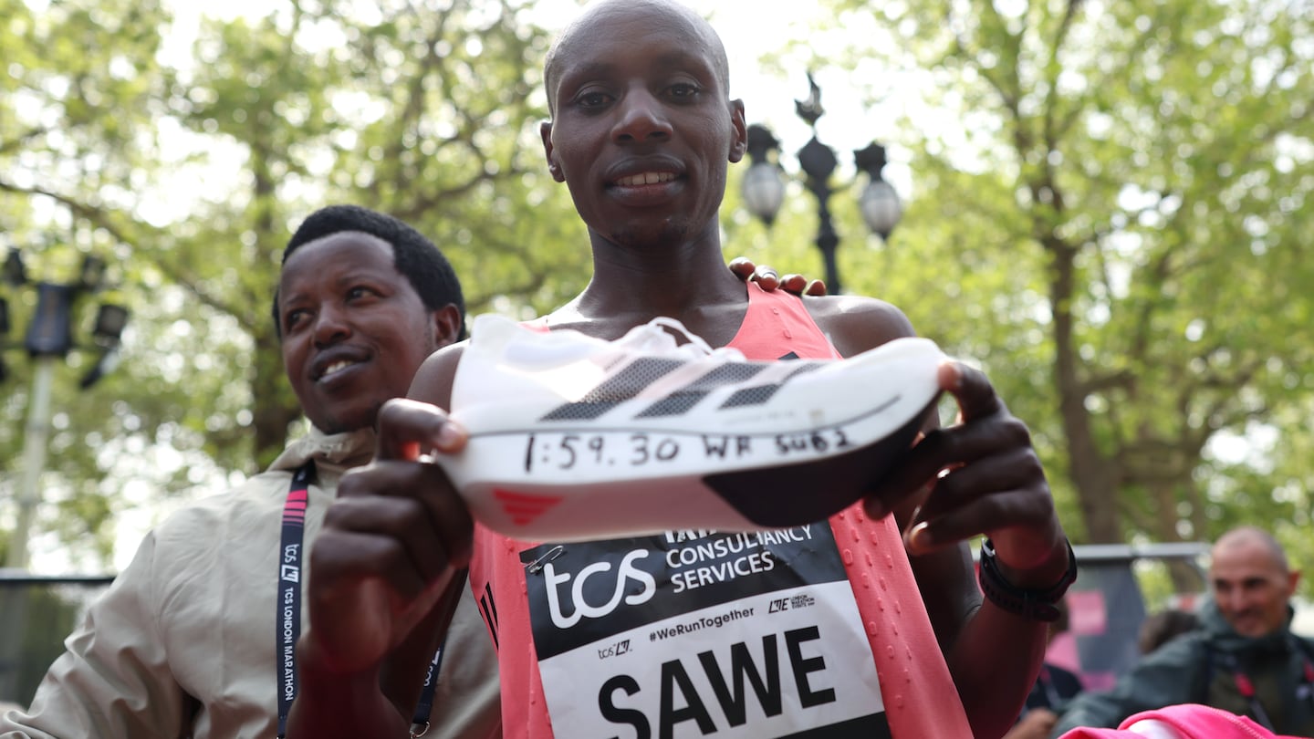 A photo of Sebastian Sawe holding the Adidas Evo SL Pro after running the first-ever sub-two-hour marathon in the shoe at the London Marathon.