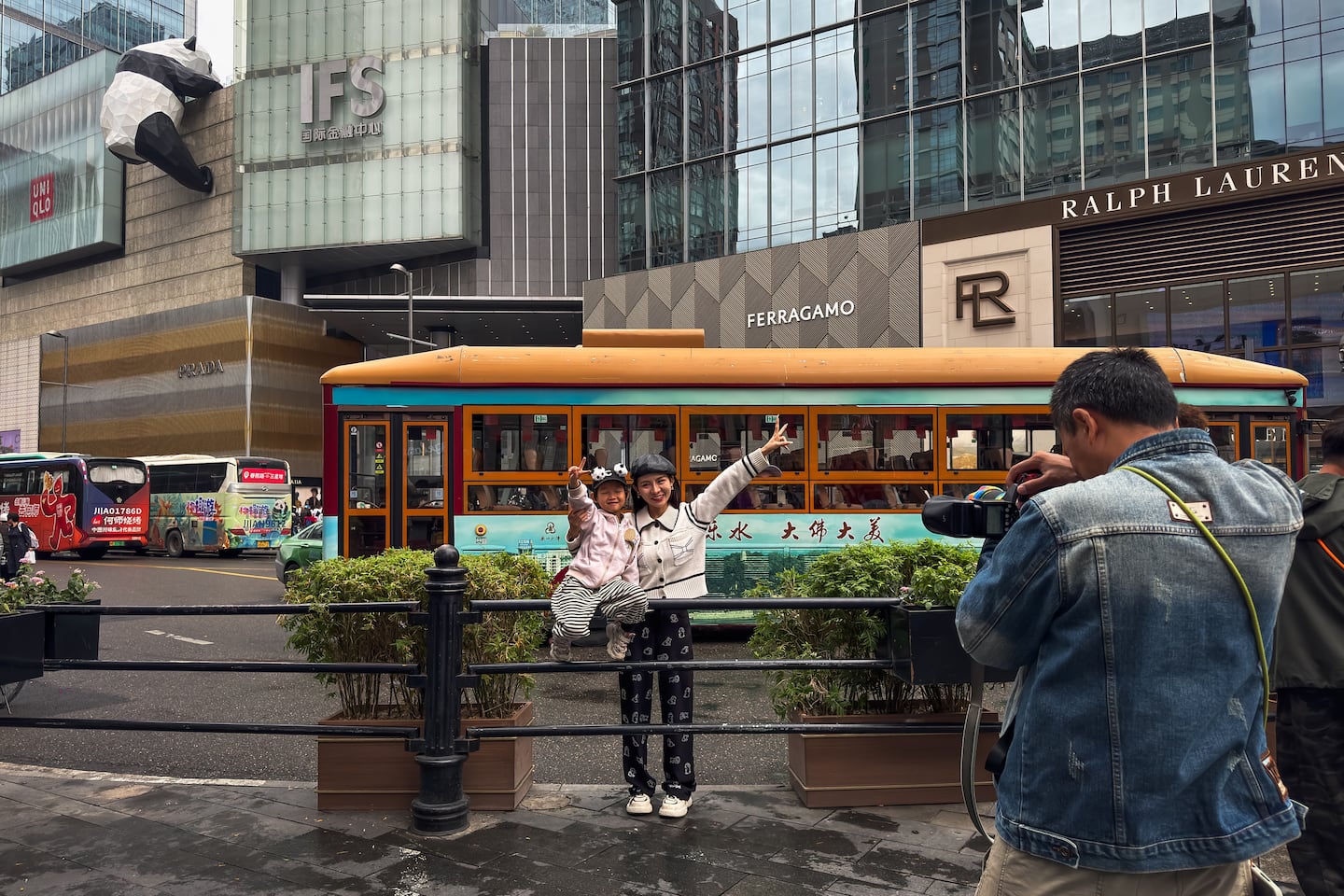 A young mother and her child pose for a photo in front of the Chengdu International Finance Square shopping mall.